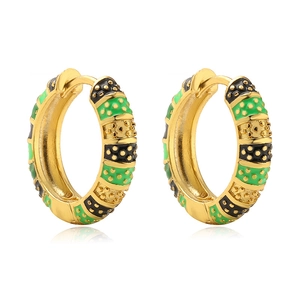 Detailed close-up of golden hoop earrings featuring green and black enamel patterns