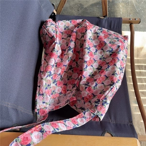 Detail of vintage floral cotton tote bag with pink rose patterns on a grey chair