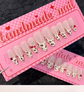 Detail of handmade press-on nails featuring leopard print tips and 3D cherry accents