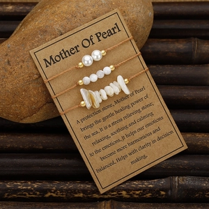 Detalle de tres pulseras de nácar presentadas en una tarjeta de exhibición natural