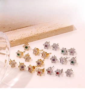 Close-up of elegant floral stud earrings with multi-colored crystals and micro-pave stones