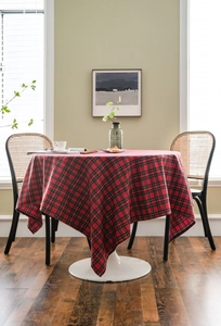 Classic red plaid tablecloth draped over a round table in a cozy home dining setting