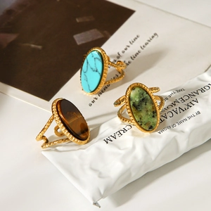 Detailed close-up of retro gold rings with turquoise and tiger eye stone inlay