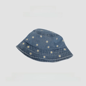 Close-up of daisy embroidery on a blue denim bucket hat with white and yellow floral patterns