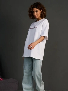 Λεπτομέρεια από oversize βαμβακερό λευκό μπλουζάκι με κόκκινη στάμπα freedom