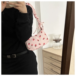 Close-up of pink corduroy shoulder bag featuring cute strawberry print and ruched strap