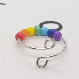 Macro view of adjustable silver wire ring featuring seven colorful sliding anxiety beads