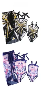 Detail view of mother and daughter matching swimwear sets with tropical and geometric prints