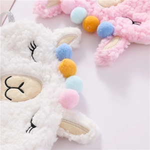 Close-up of plush alpaca sleep masks in white and pink with fuzzy wool texture