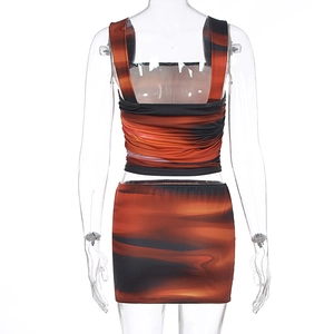 Detail of tie-dye crop top and mini skirt set with vibrant orange and black patterns