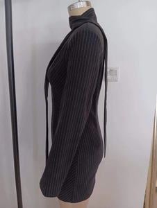 Detail eines schwarz gestreiften Langarmkleides mit Fokus auf Taille und Passform