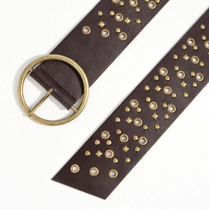 Close-up of vintage brown leather belt with brass buckle and metallic rivets