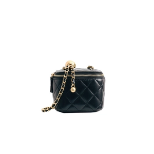 Detail shot of black quilted leather mini vanity bag with golden ball chain adjuster