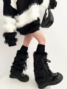 Gros plan sur des jambières en fausse fourrure noire avec pull rayé et bottines