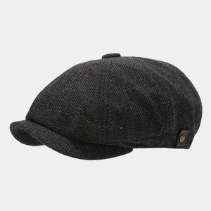 Close-up of herringbone newsboy cap with leather side tag and bronze metal buckle