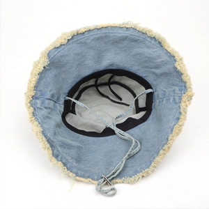 Detail of light blue denim sun hat showing frayed edges and adjustable chin strap