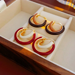 Vue détaillée des boucles d'oreilles double cercle en émail rouge, blanc, marron et noir