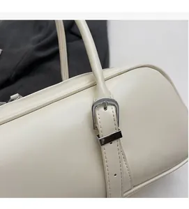 Detailed close-up of ivory faux leather baguette bag showing silver adjustable strap buckle