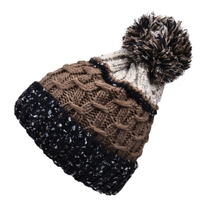 Détail d'un bonnet d'hiver en tricot avec textures multicolores et grand pompon soyeux