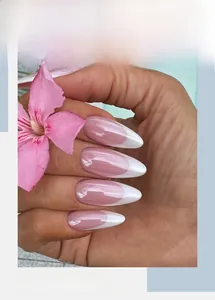 Detail of almond-shaped French press-on nails with nude pink base and white tips