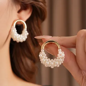 Orecchini a cerchio a U vintage dorati con perle indossati da modella donna