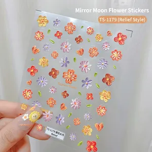 Detail of 5D embossed nail stickers featuring colorful floral daisy designs and 3D textures