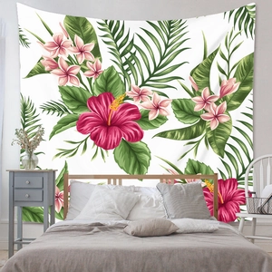 Detail of bohemian tapestry featuring vibrant tropical hibiscus and palm leaves in a bedroom