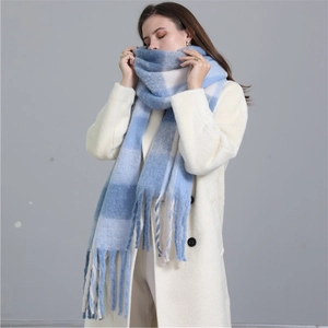 Détail d'une écharpe à carreaux bleus et blancs avec franges portée par un mannequin