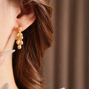 Close-up of elegant gold beaded tassel earrings on model with high quality finish