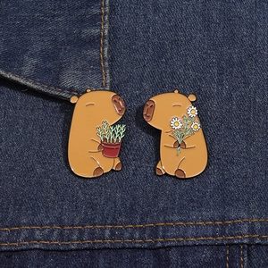 Detail of cute Capybara enamel pins with flowers and plants on denim fabric jacket