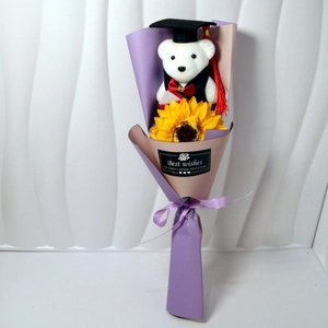 Close-up of graduation bear with sunflower and artistic Best Wishes label in purple wrap
