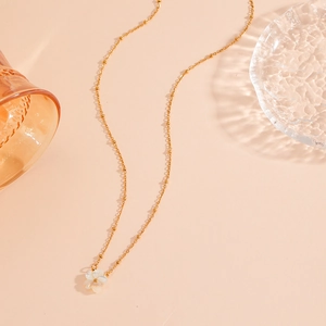 Gold titanium steel necklace featuring a white shell flower pendant on a beaded chain
