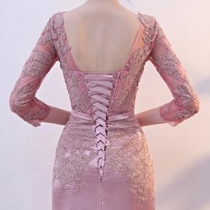 Detailed back view of lace evening gown featuring elegant corset-style lacing and floral texture