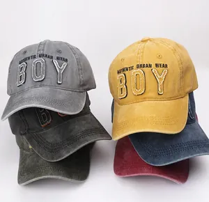 Detail of embroidered BOY patch on vintage washed cotton baseball caps in various colors