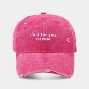 Macro shot of distressed peach pink washed cotton baseball cap with white embroidery