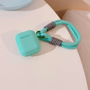 Detailed view of cyan silicone AirPods case with matching woven lanyard on white surface
