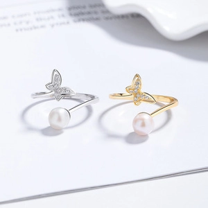 Detailed view of sterling silver butterfly rings with sparkling zircon and white pearls