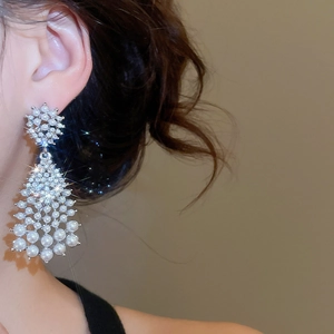 Close-up of tassel drop earrings featuring white pearls and sparkling rhinestones