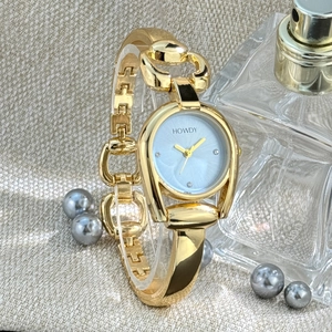 Detail of horseshoe-shaped gold watch with light blue dial and metal link bracelet