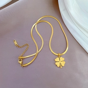 Detail of gold snake chain with clover pendant and S.STEEL hallmark engraving