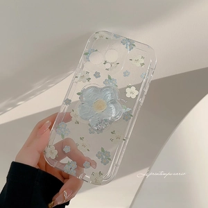 Close-up of clear phone case with blue floral patterns and matching flower grip stand