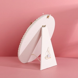 Oval pearl border jewelry display stand with a white velvet finish and back support