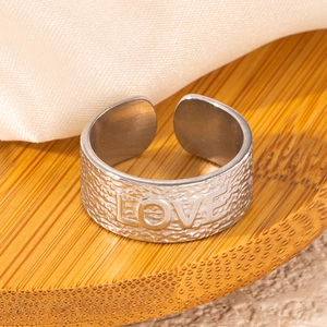 Close-up of a silver titanium steel LOVE ring with a hammered rock texture finish