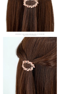 Detail of rose gold crystal leaf hair clip on brown hair showing the spring clip mechanism