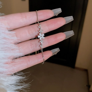 Macro shot of silver zircon flower bracelet with adjustable drawstring chain for women