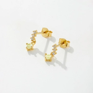 Close-up of S925 sterling silver gold-plated earrings with green and white zircons