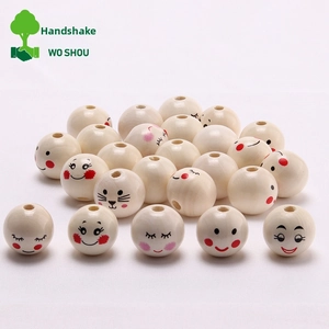 Macro detail of 20mm natural wooden beads with cute printed faces and pre-drilled holes