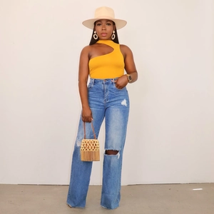 Gelbes One-Shoulder-Top für Damen und blaue High-Waist Wide-Leg Ripped Jeans mit Accessoires