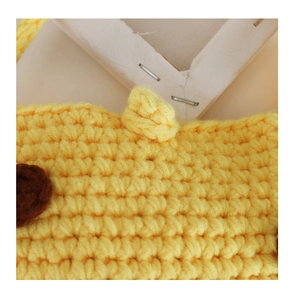 Close-up of yellow crochet knit giraffe bag featuring handmade textures and brown ears