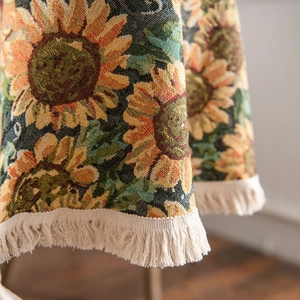 Thick woven round tablecloth featuring sunflower patterns and decorative beige fringe